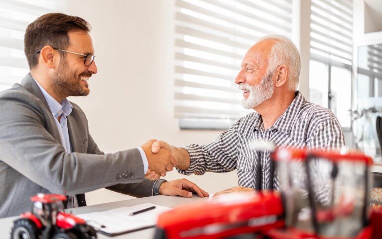 Farmer shaking hands with business person