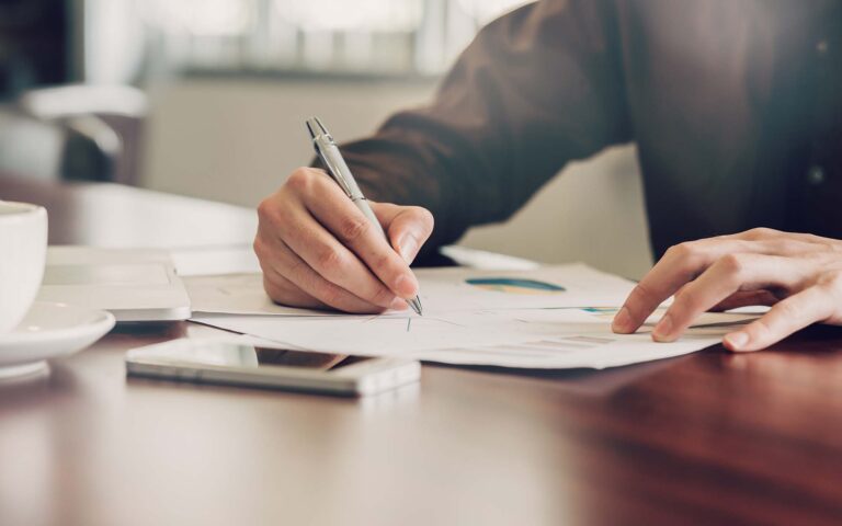 business-man-hand-writing-note-paper-on-wooden-table_