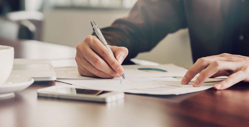 business-man-hand-writing-note-paper-on-wooden-table_